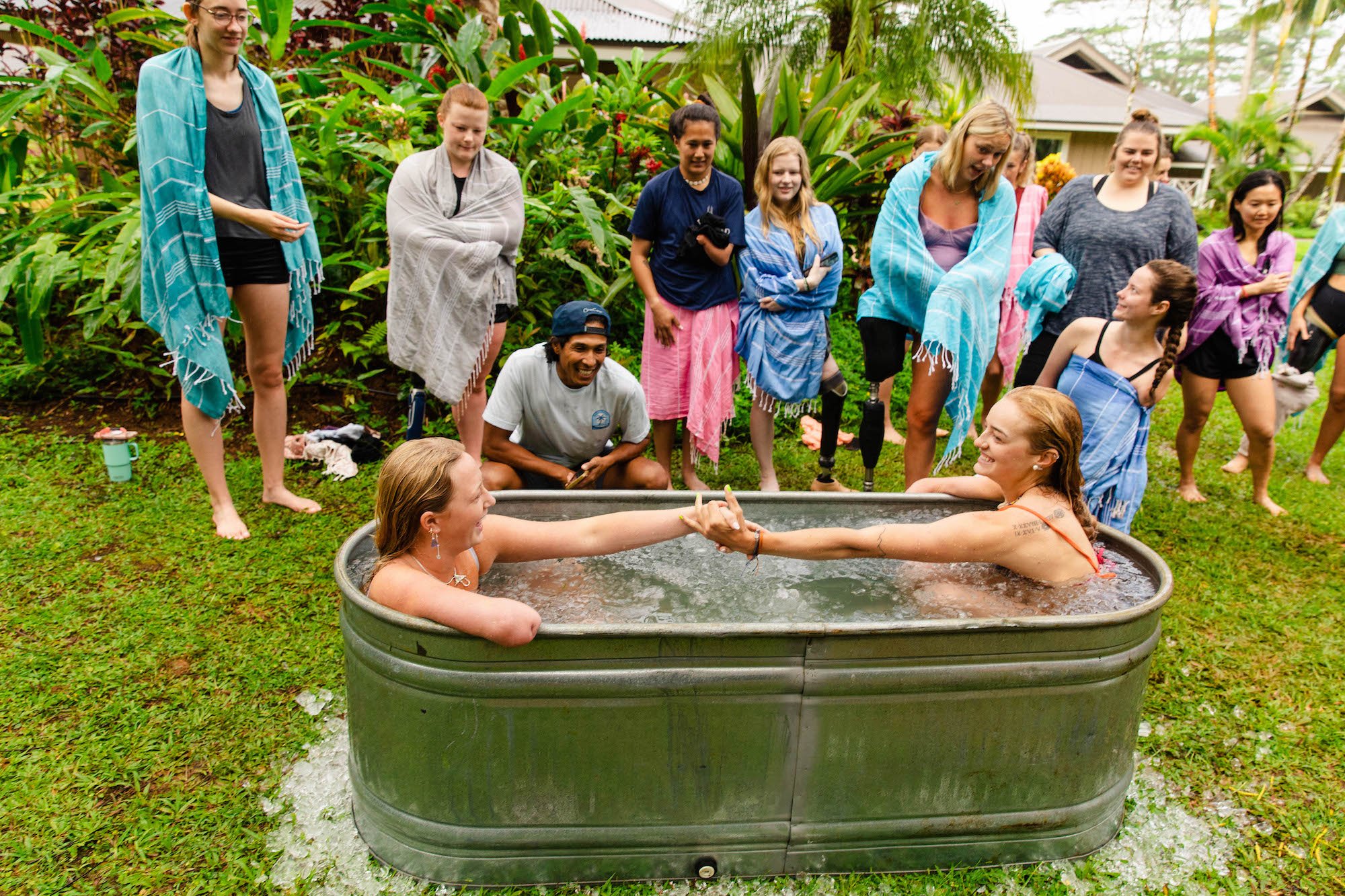 Retreat attendees helping each other out of the ice bath