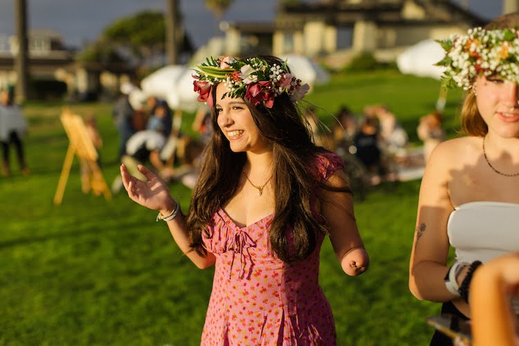 Beautifully Flawed attendee Lina smiles showing off the beautiful haku lei she made as well as her limb difference