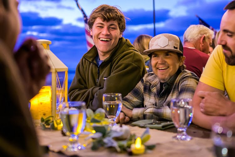 Two Forge men smile and laugh at the dinner table.