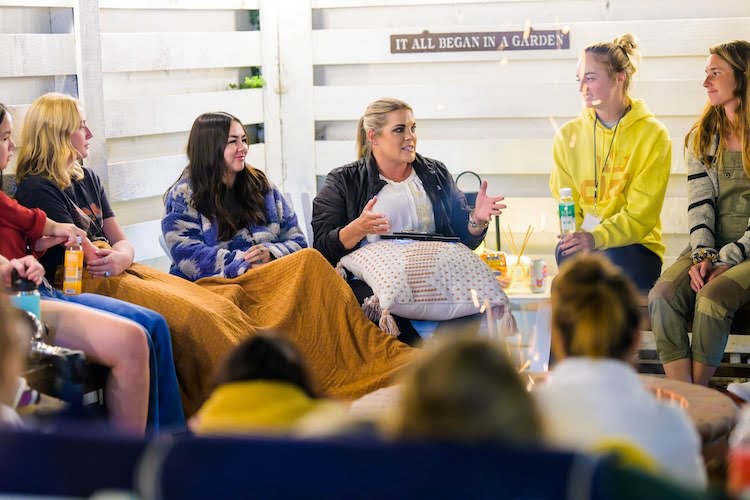 Sarah Hill shares a message to the Beautifully Flawed attendees around the fire pit during a group session.