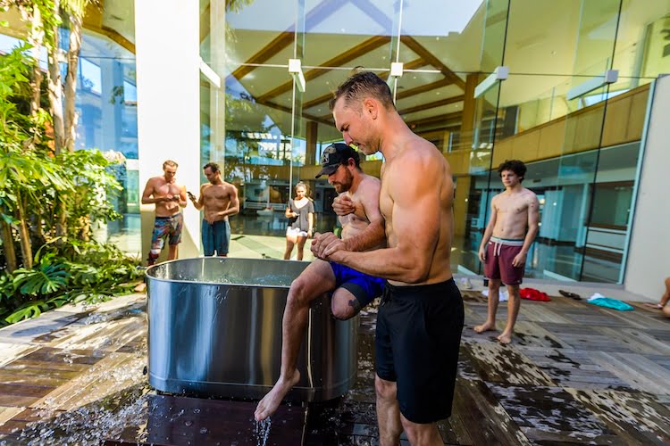 Adam Dirks help a Forge attendee and leg amputee out of the ice bath.