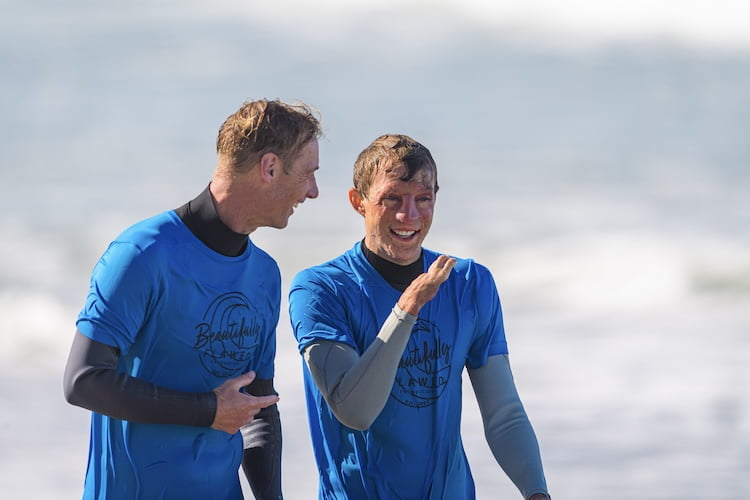 Forge attendee comes out of the ocean beaming after learning how to surf adaptively.