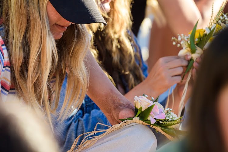 A Beautifully Flawed attendee with an arm limb difference finds a way to adaptively make her haku lei and weave in the flowers with her one hand.