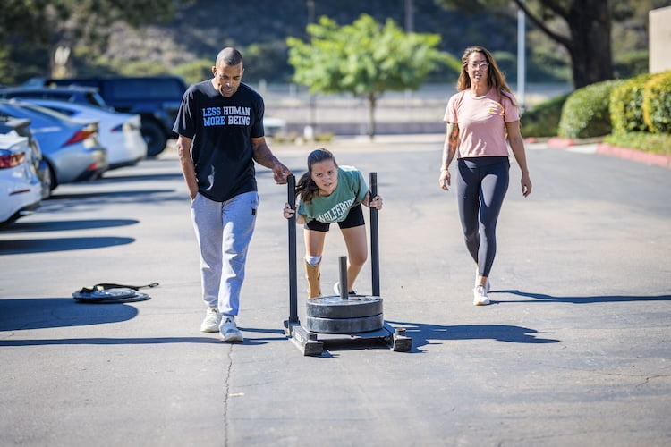 Attendee Maria pushes a weighted sled even with her right leg limb difference.